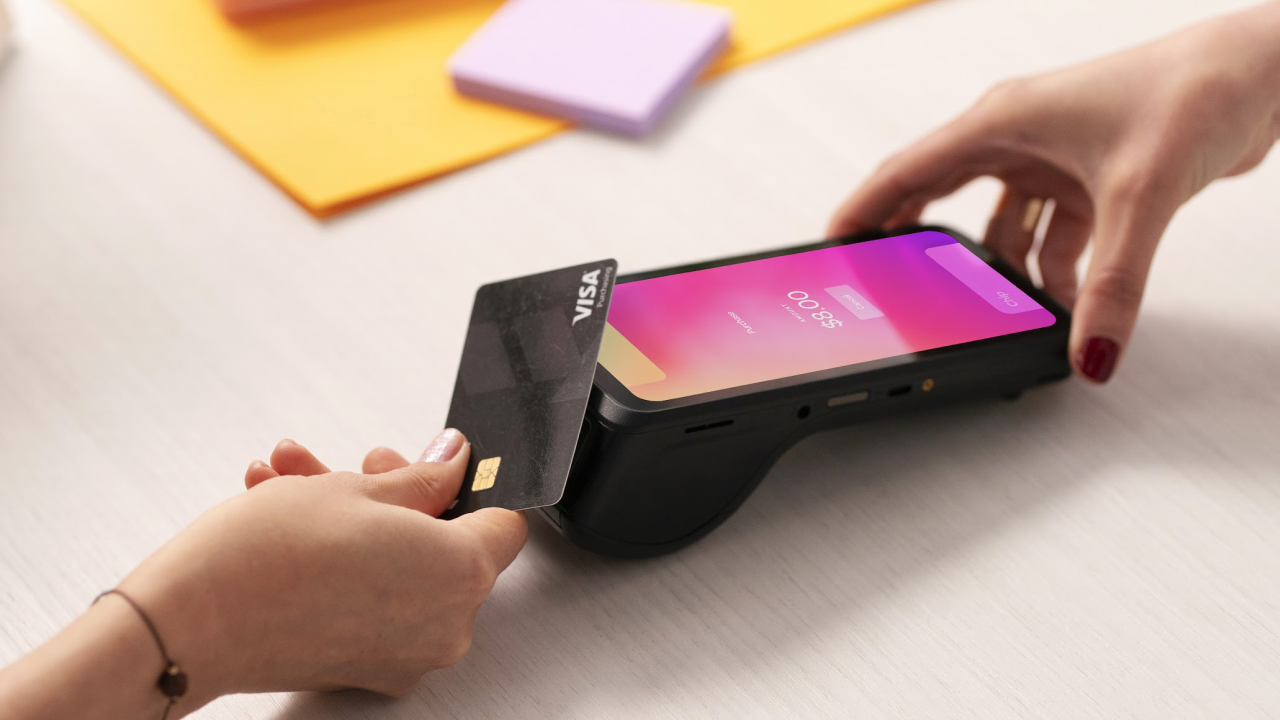 Merchant presenting a pos machine with customer tapping her card