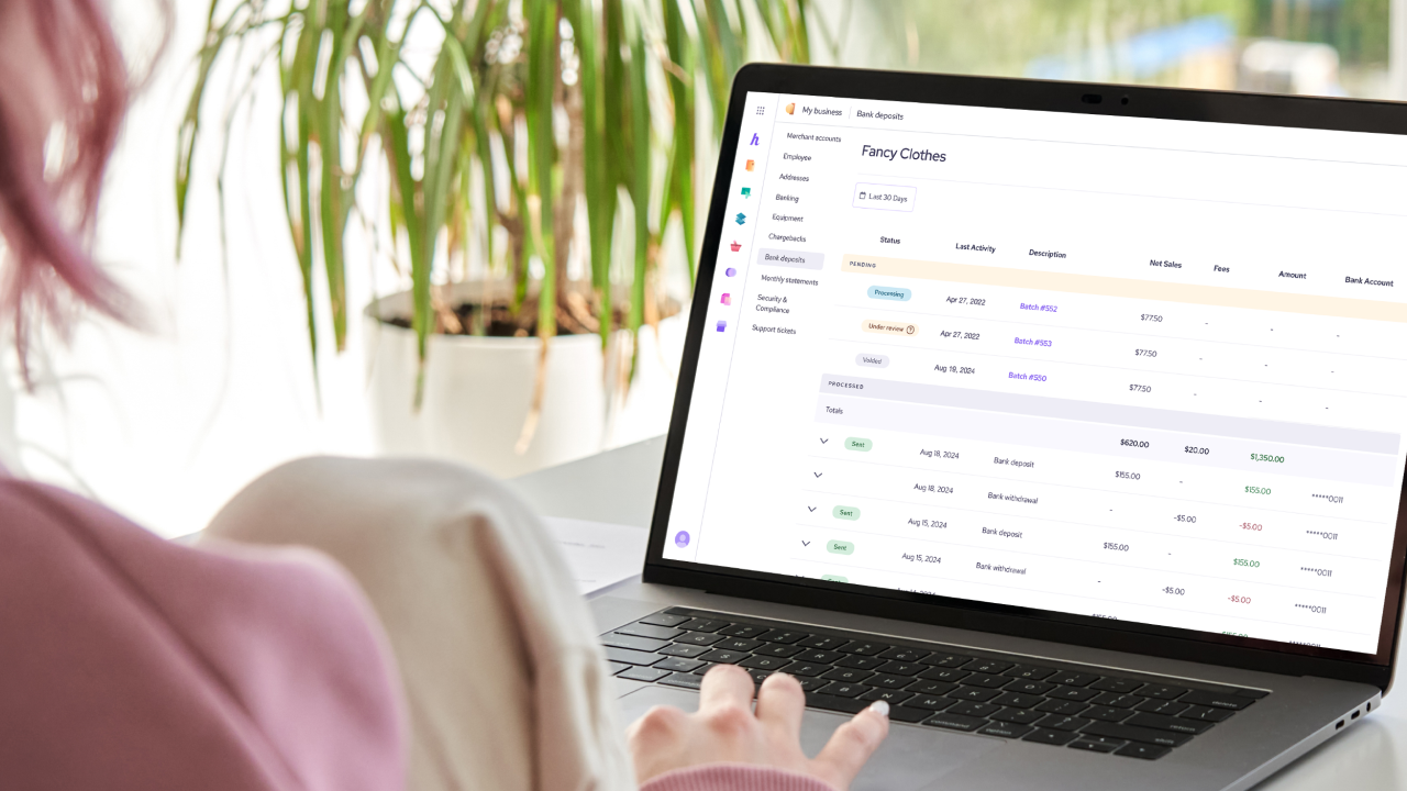 merchant looking at her bank deposit on their laptop