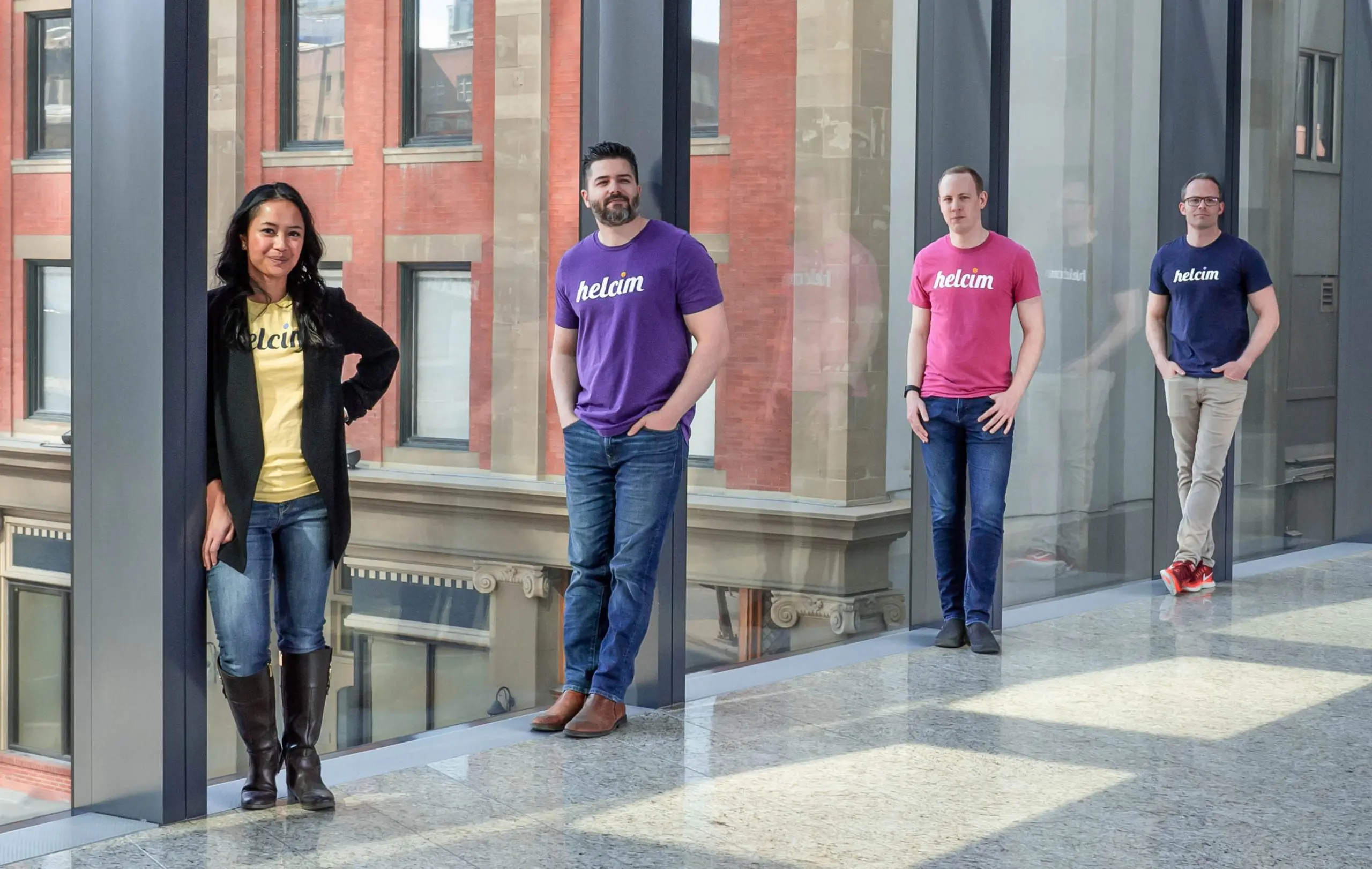 Four Helcim executives lean on pillars for photo