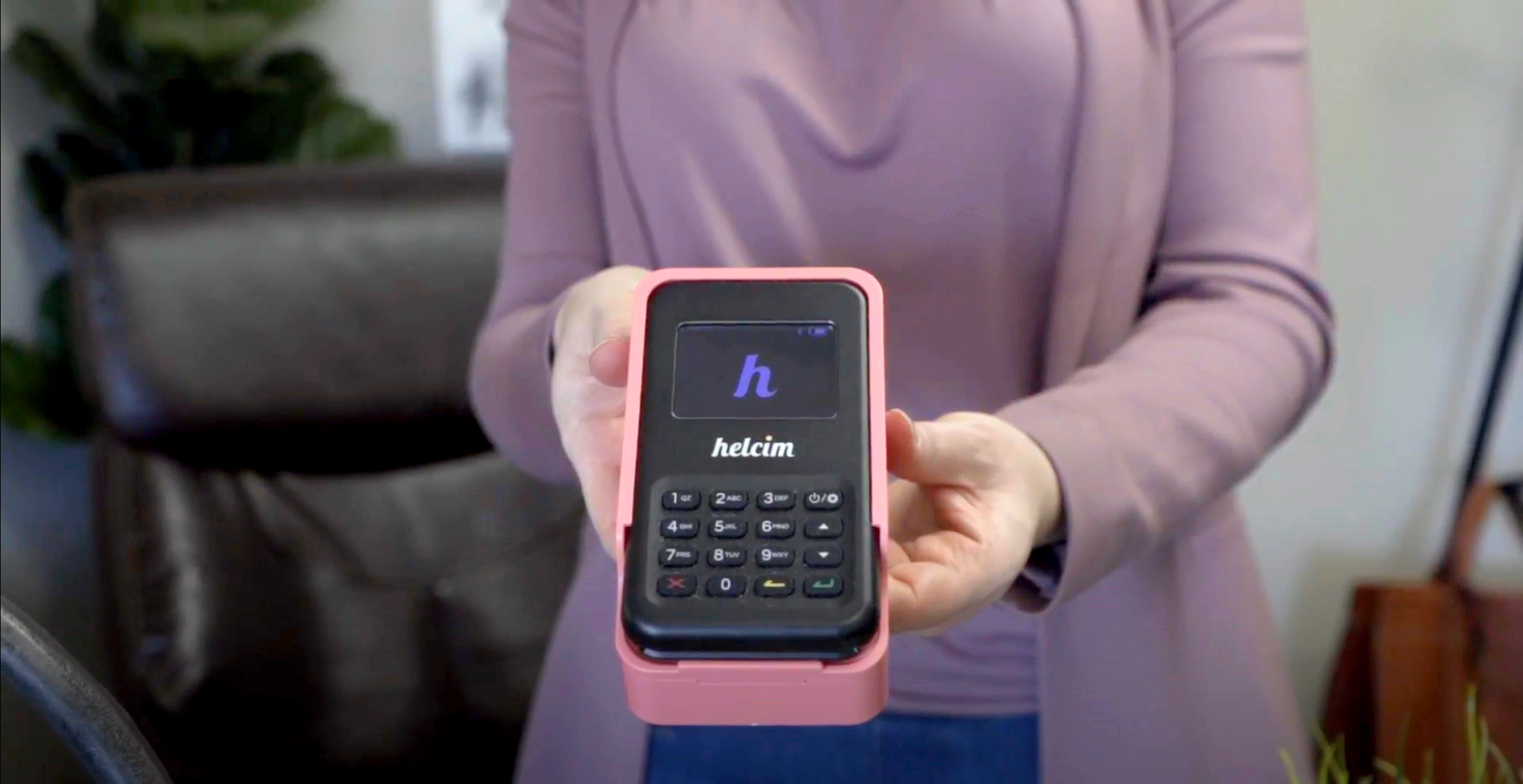 A woman holding a Helcim Card Reader
