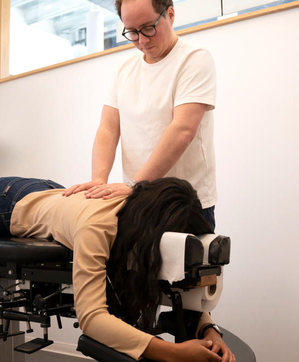 Chiropractor practices with woman