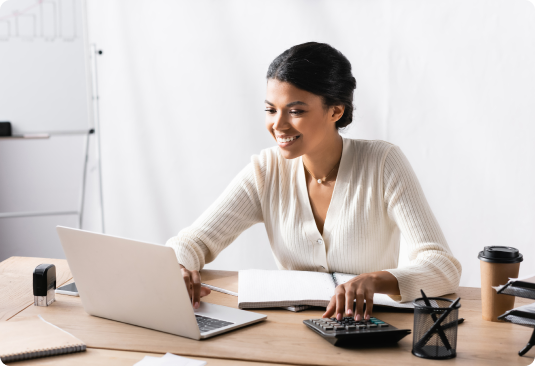 Happy African American woman looking at laptop image