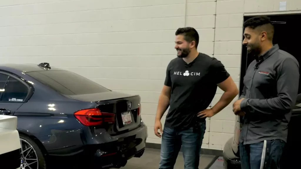 Nic standing next to automobiles